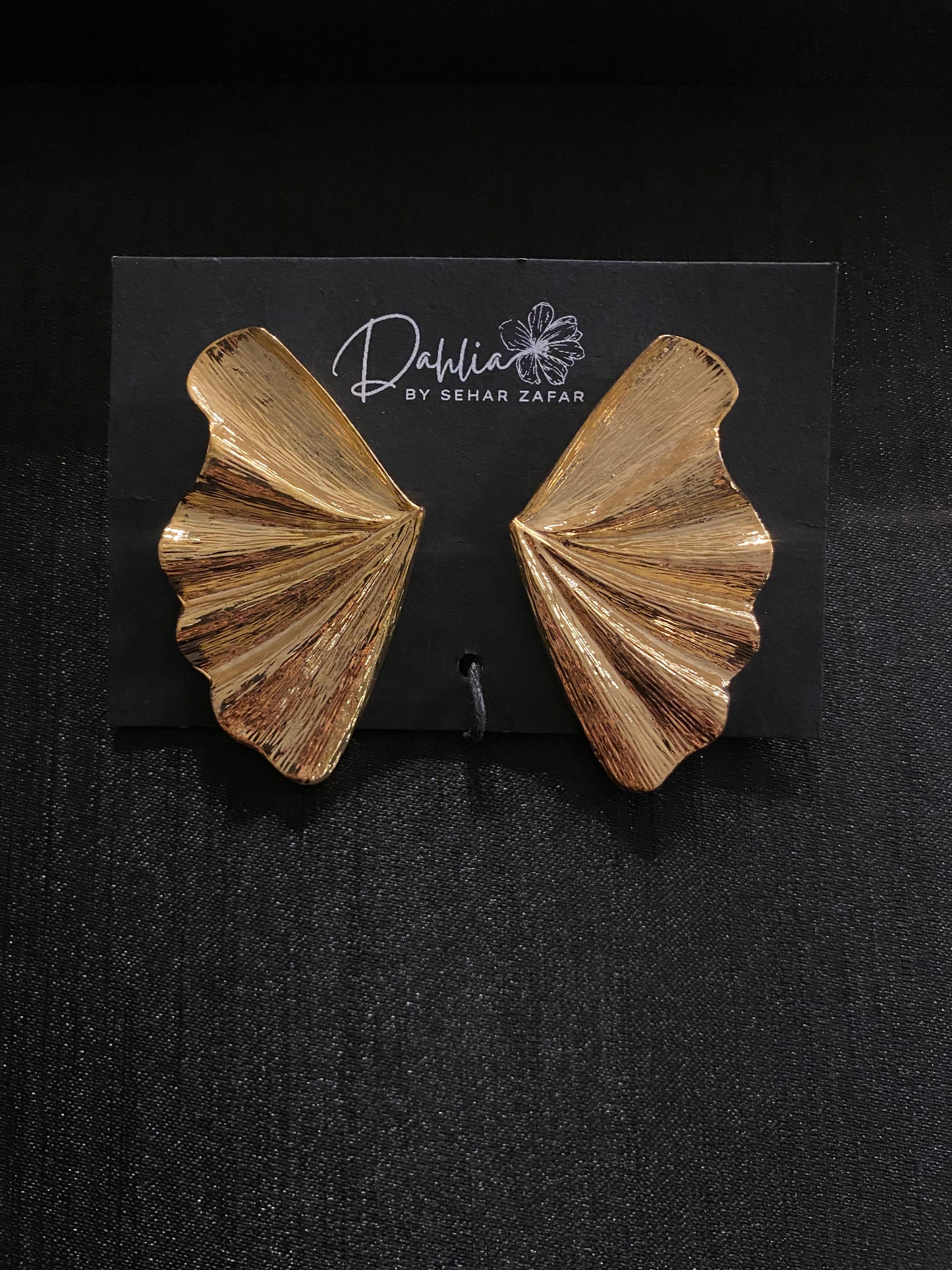 Gold textured fan shaped statement earrings displayed on Dahlia by Sehar Zafar card