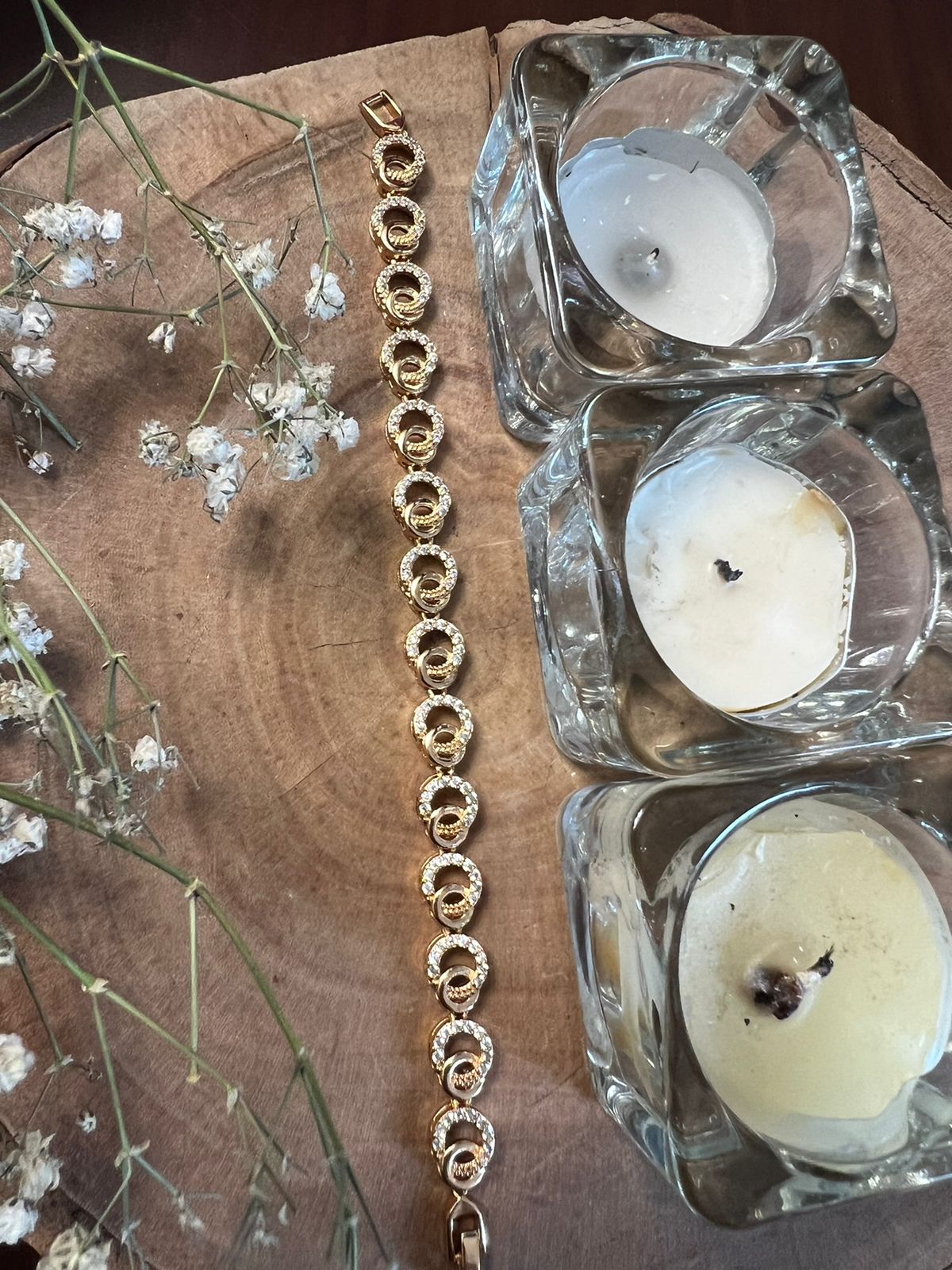 Luxury necklace sets with green teardrop stones, clear faceted gems, and gold detailing on dark velvet stand