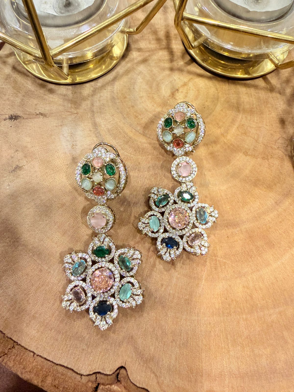 Multicolored gemstone earrings on a wooden surface