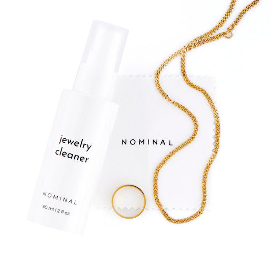 Fine jewellery being gently cleaned and stored in a luxury flat lay setting, highlighting proper care and maintenance.