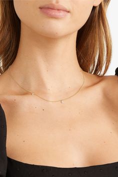 Minimal gold jewellery styled with jeans and a white t-shirt, photographed
