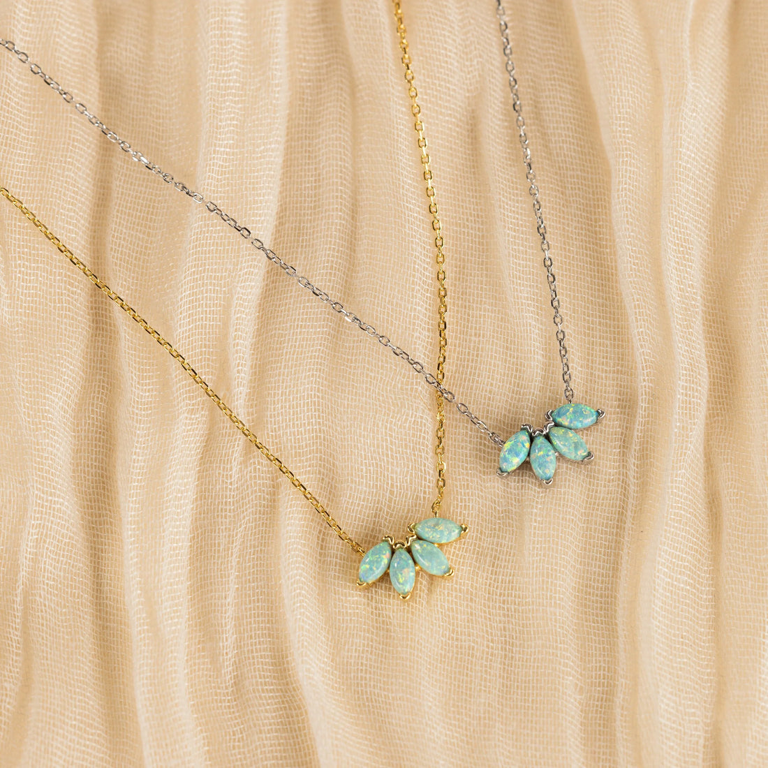 Modern luxury gold and gemstone jewellery styled on neutral fabric in soft natural light