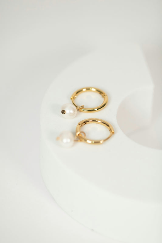 a pair of gold hoop earrings on a white background