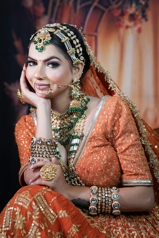 A woman in an orange and gold bridal outfit