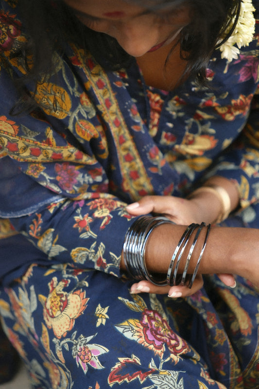 Woman wearing a floral print saree with bangles