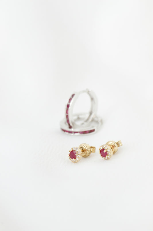 Two pairs of ruby and diamond earrings on white background