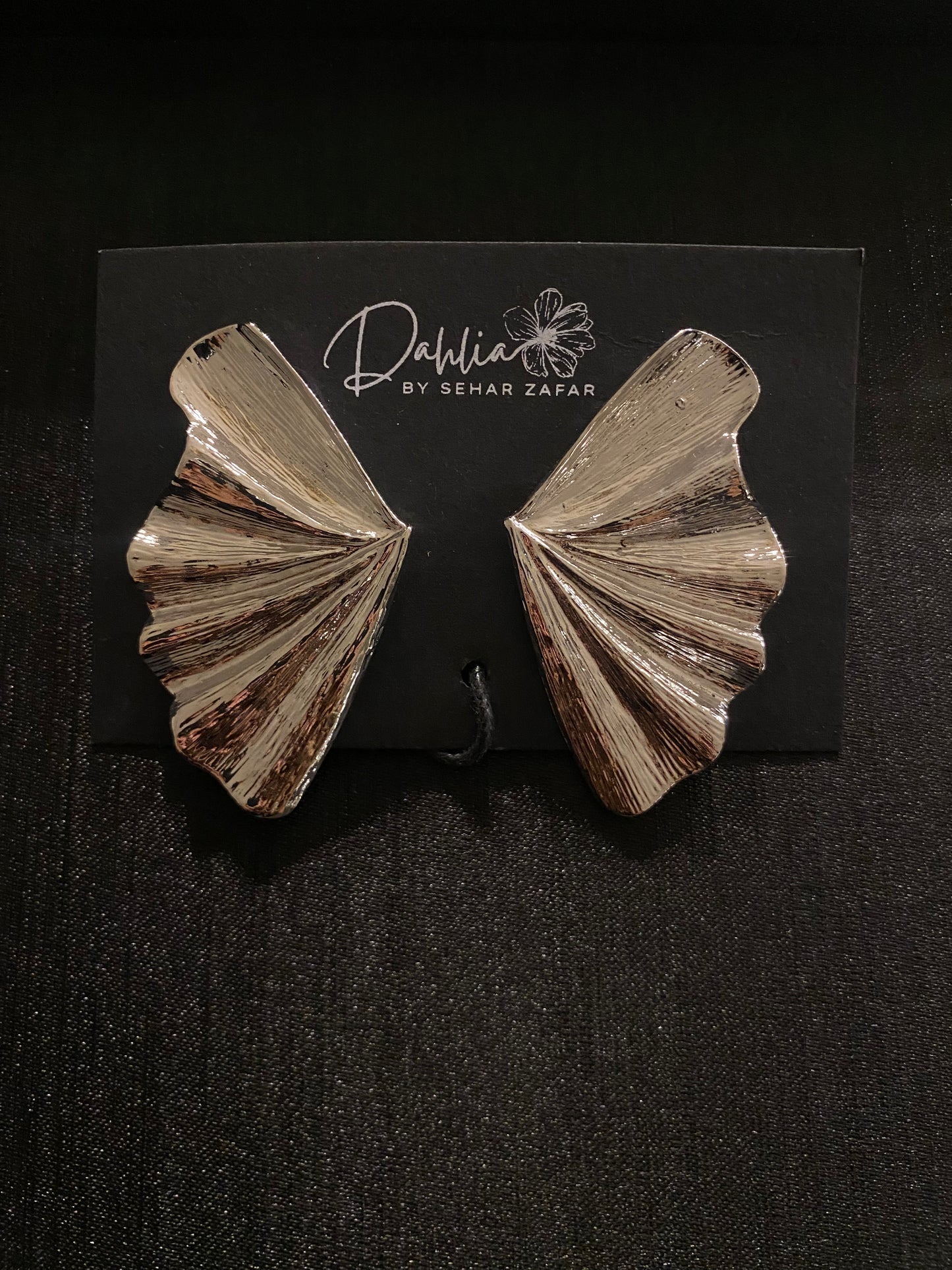 Gold textured fan shaped statement earrings displayed on Dahlia by Sehar Zafar card