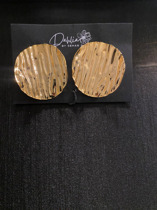 Large round gold earrings with wavy texture on black branded card