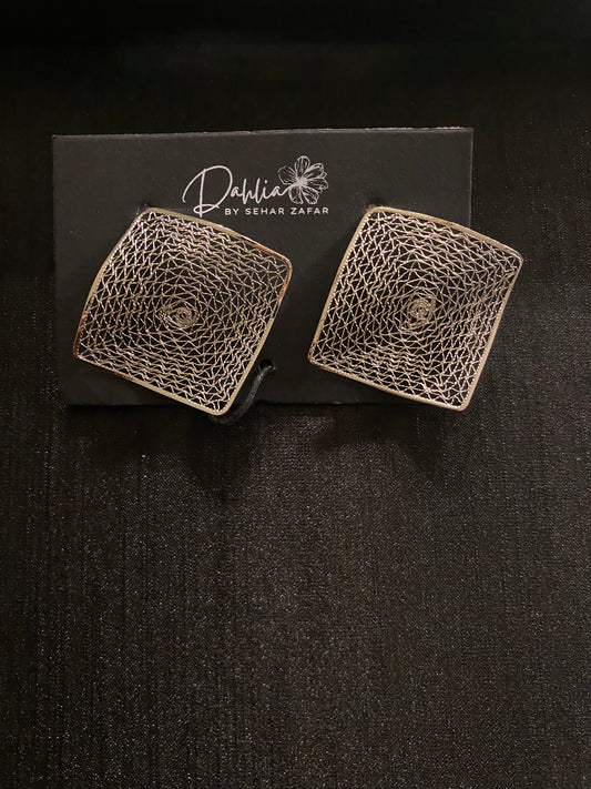 Square earrings with geometric web pattern on black branded card