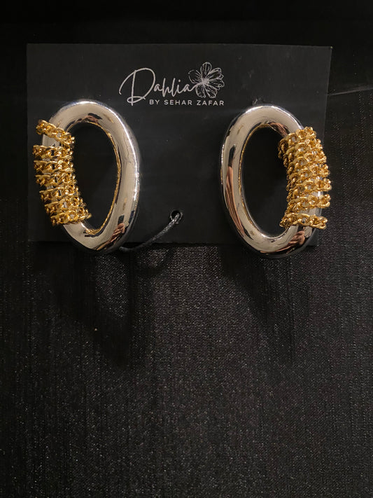 Silver oval hoop earrings with gold chain wrap on black branded card