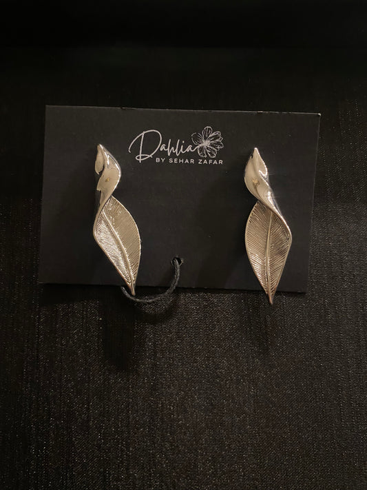 Silver leaf-shaped earrings with vein and petal detail on black branded card