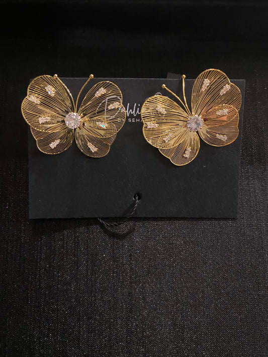 Gold wire butterfly earrings with gemstone wings on black branded card