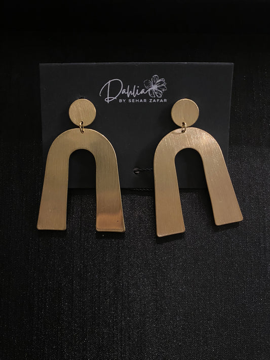 Gold geometric arch earrings with brushed texture on black branded card