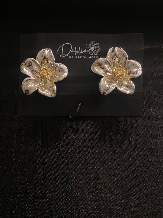 Silver flower earrings with gold stamen detail on black branded card