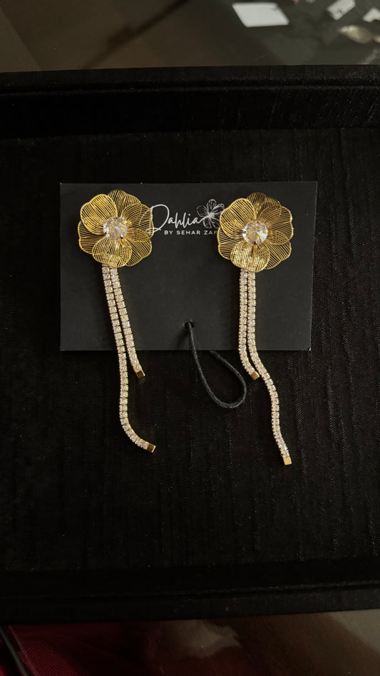 Gold floral earrings with crystal drops and petal detailing on black branded card