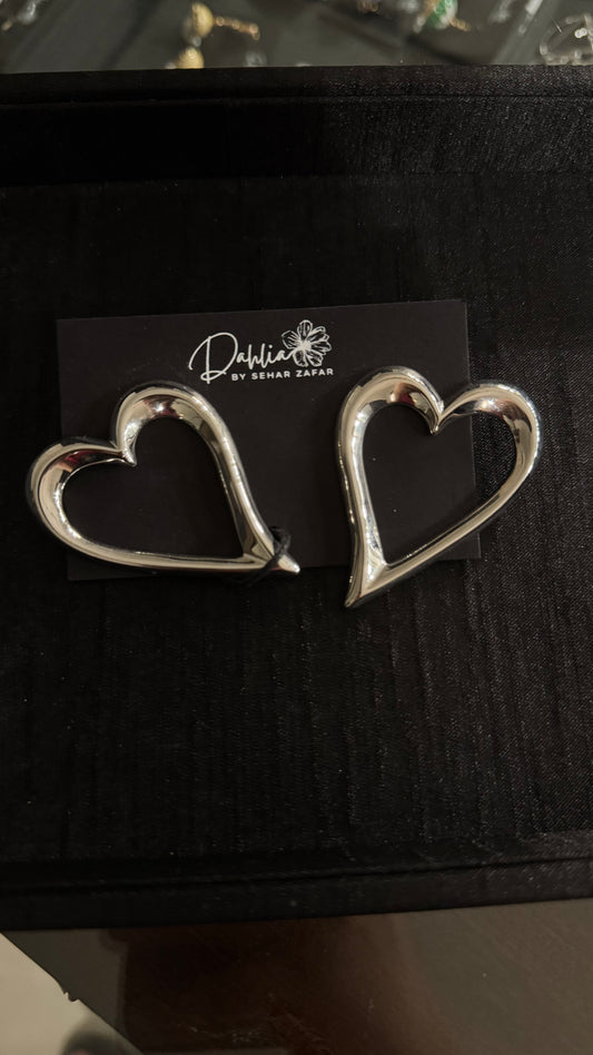 Gold heart-shaped accessories with sleek modern design on black branded card