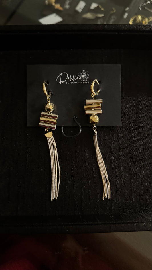 Gold hoop tassel earrings with faceted bead and geometric stack on black branded card