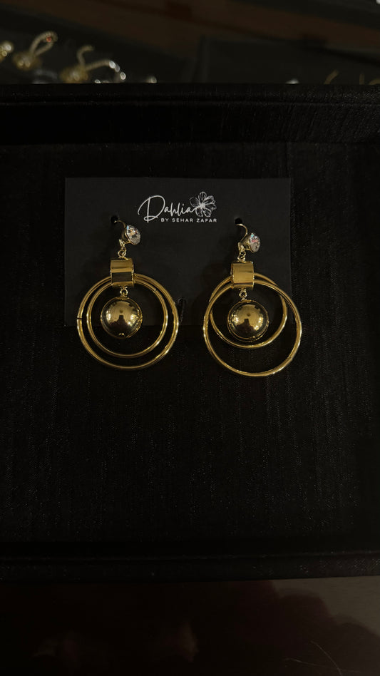 Gold double hoop earrings with central bead and gem stud on black branded card