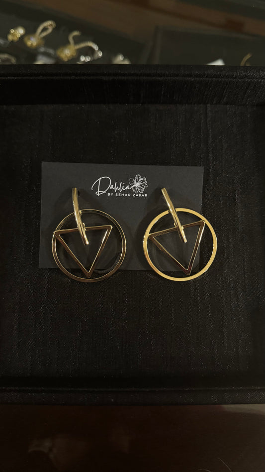 Gold geometric earrings with triangle and circle frame design on black branded card