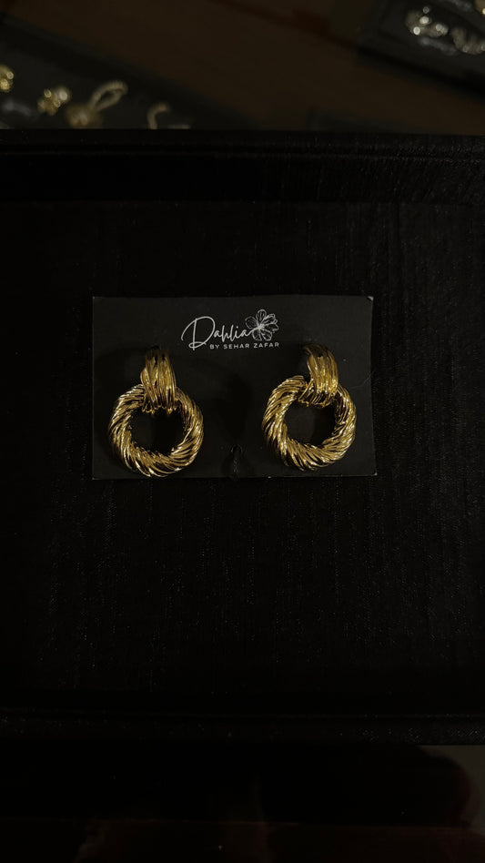 Gold textured hoop earrings with twisted rope design on black branded card