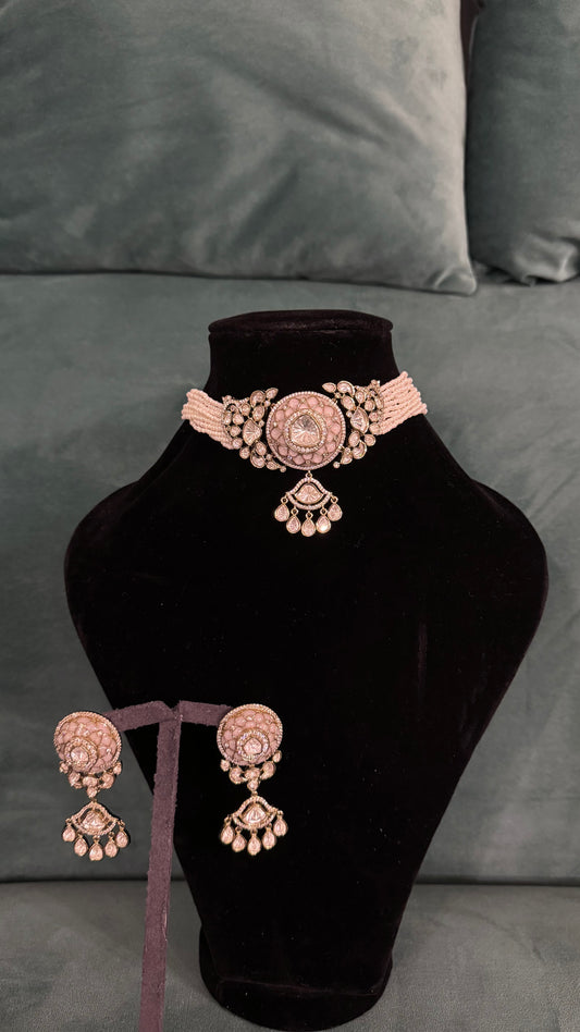Traditional choker necklace sets with circular pendant, teardrop accents, and pearl detailing on black velvet stand