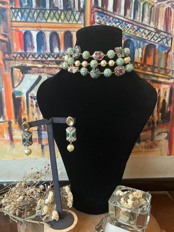 Beaded choker with pastel enamel beads, pearls, and 24 karat gold plating displayed with matching earrings.