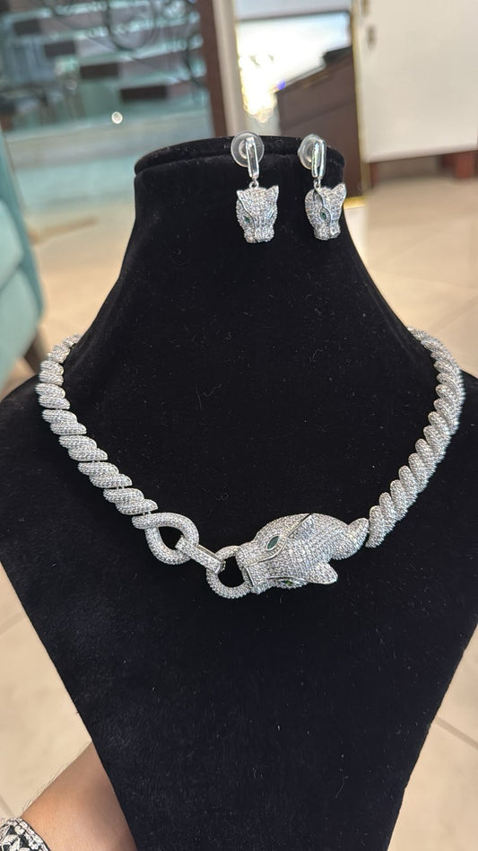 Silver elephant necklace and earrings on a black stand with a blurred background