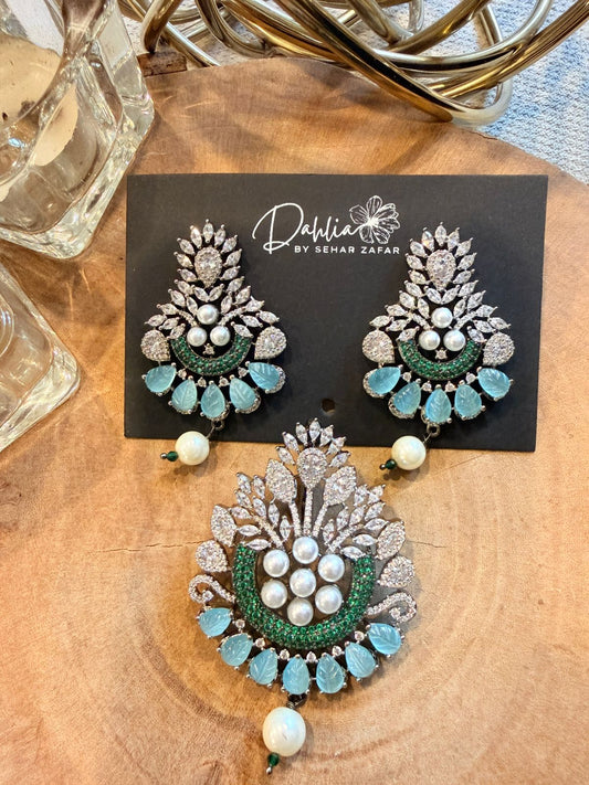 Decorative earrings on a wooden surface with a brand card in the background.