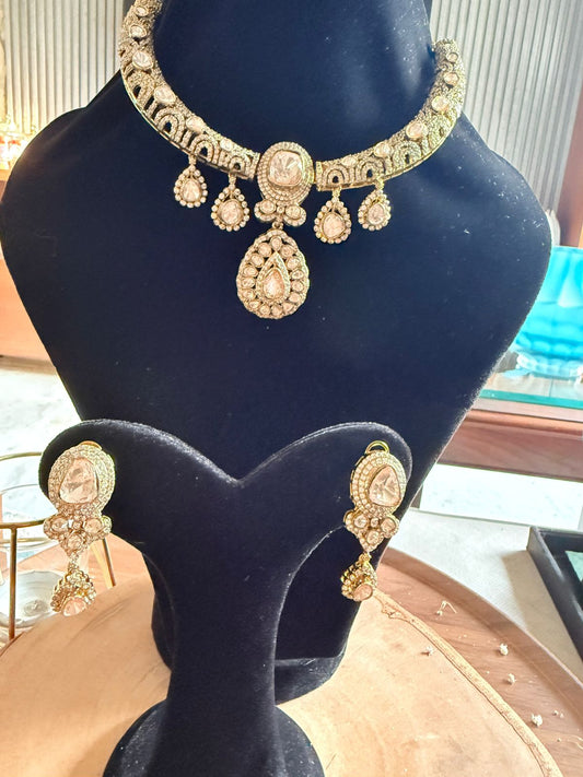 Gold necklace and earrings on a mannequin bust with a blurred background