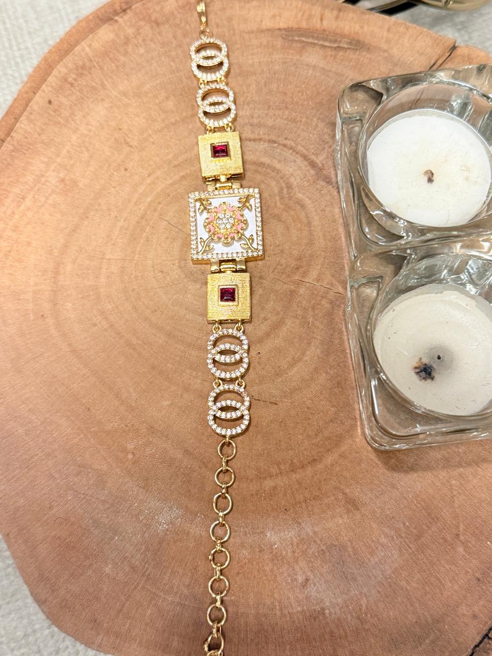 Gold bracelet with gemstones on a wooden surface with candles