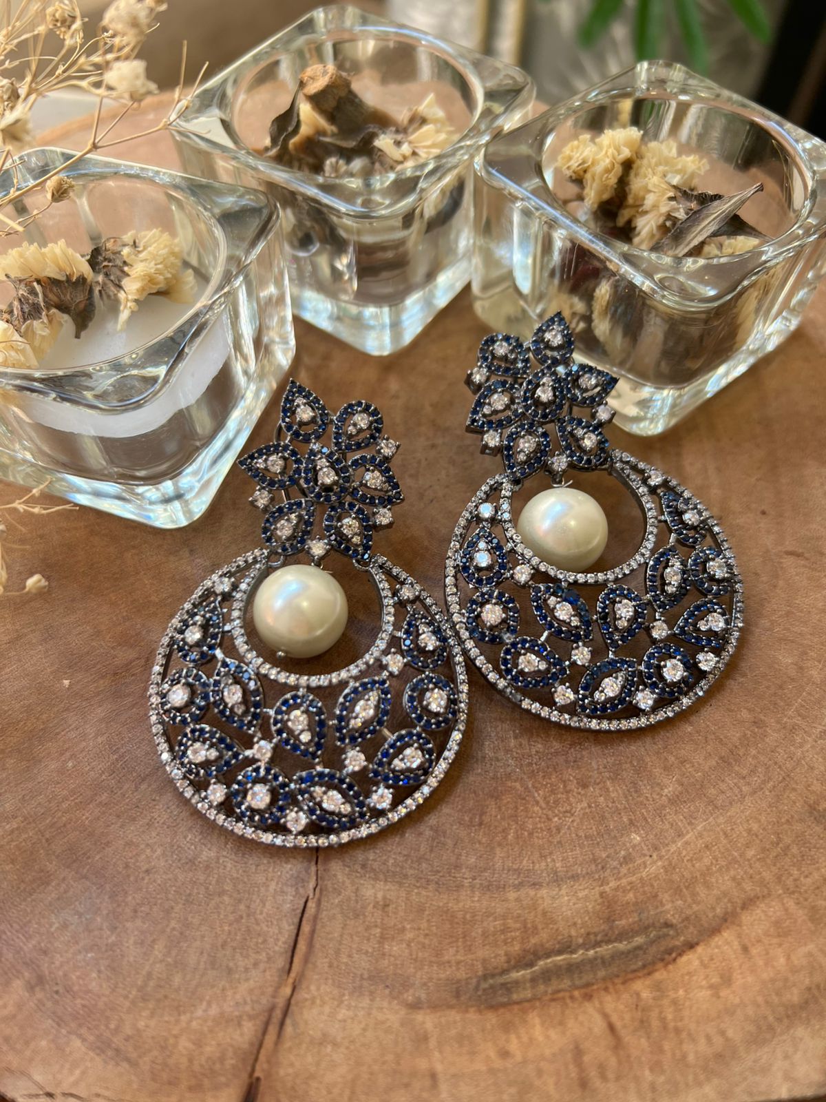 Decorative earrings with pearls on a wooden surface